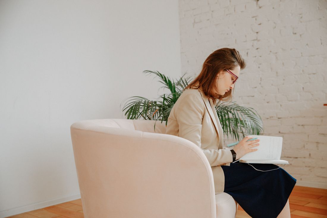 A professional reviewing her notes in a counselling setting