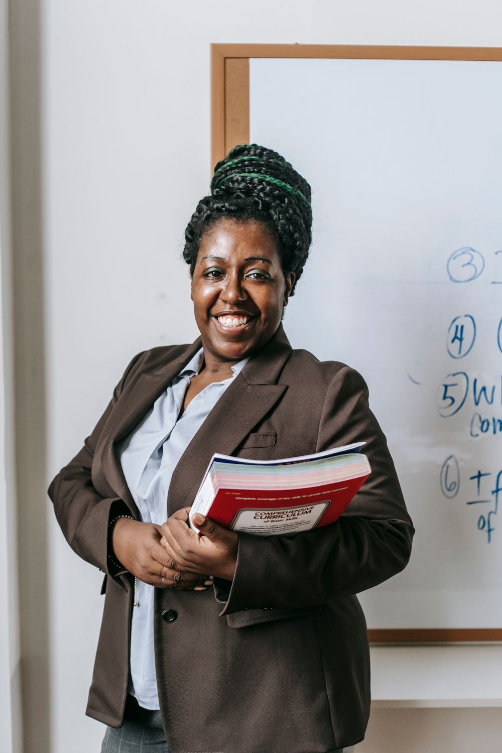 A teacher standing beside a classroom whiteboard